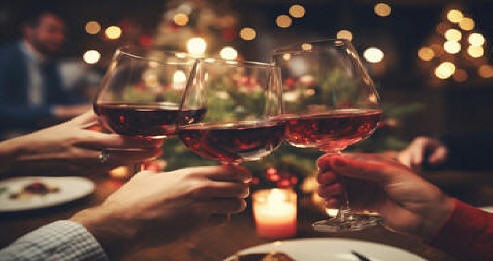 Close up of hands toasting wine glasses at dinner party on christmas at home